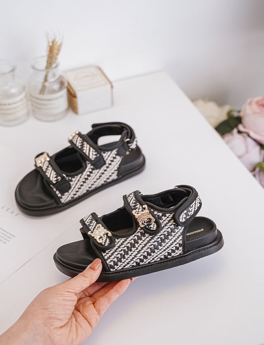 Sandales blanches et noires pour filles avec boucles dorées. Style raffiné et confort pour l’été, disponibles sur Hortensiaa.

