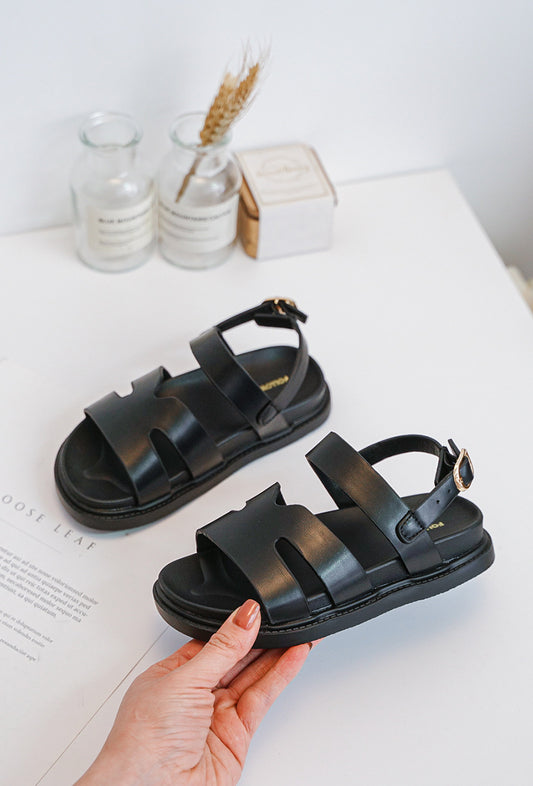 Sandales noires pour filles : un basique chic et confortable, idéal pour l'été. À porter avec robes, jupes ou pantalons.